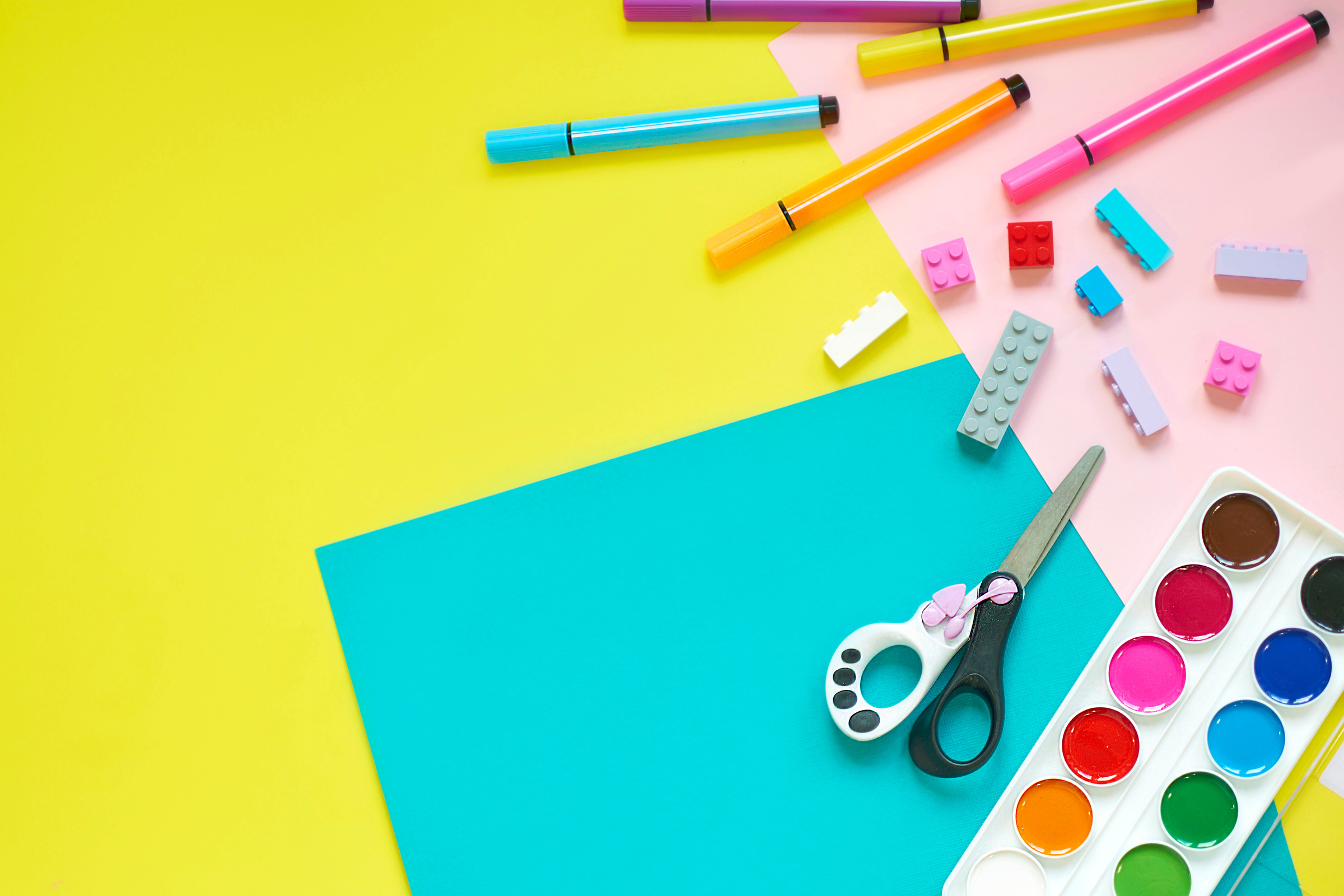 School supplies, stationery on yellow background - space for caption. Child ready to draw with pencils and make application of colored paper. Top view